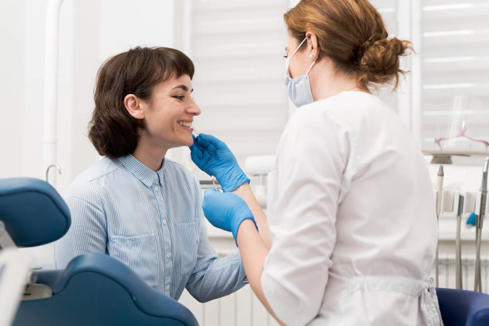 a woman getting her teeth check out by a dentist