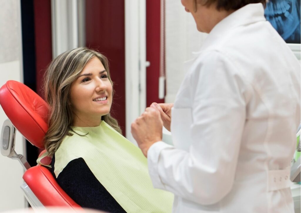 Dentist consulting with a patient about the difference between dental crowns and veneers during a cosmetic dentistry appointment.