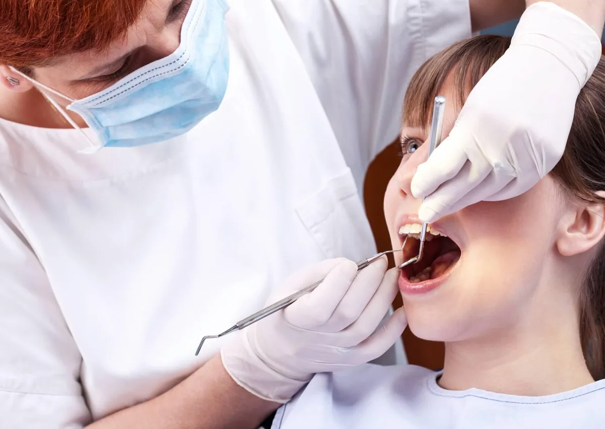 Dentist examining a patient’s molars before applying dental sealants for cavity protection.