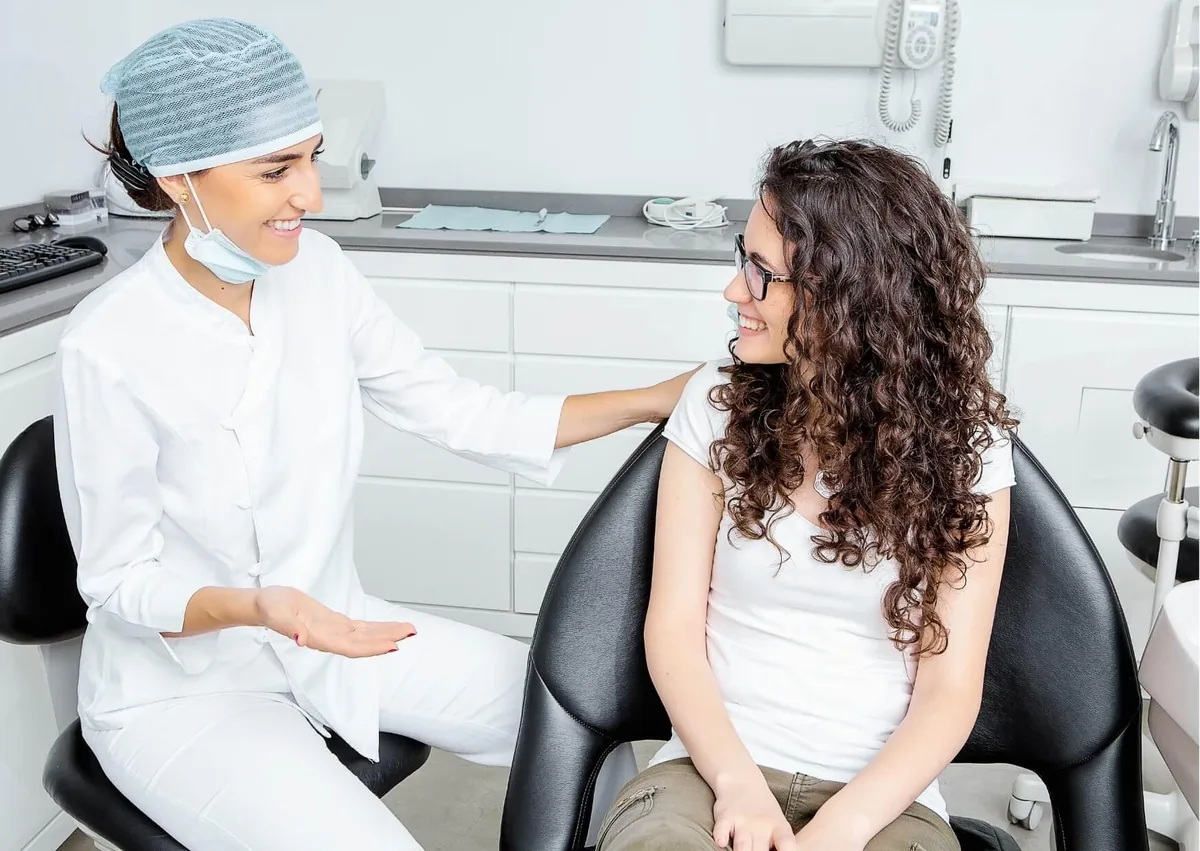 Dentist discussing full mouth dental implant treatment and cost options with a patient during a consultation.
