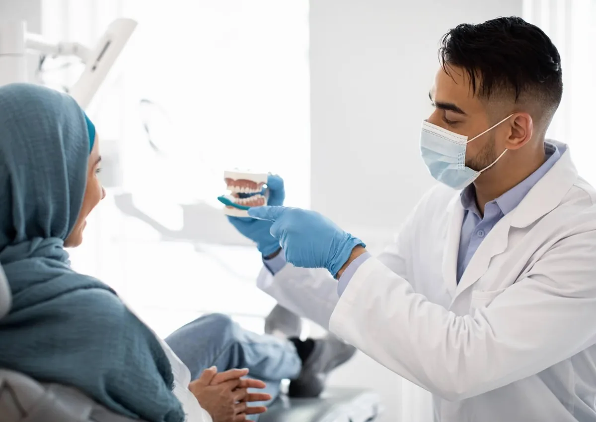 Dentist discussing how to protect cosmetic dentistry treatment results with a patient using a dental model.
